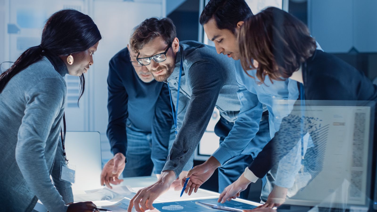 Forschende beugen sich über ein Papier und diskutieren.