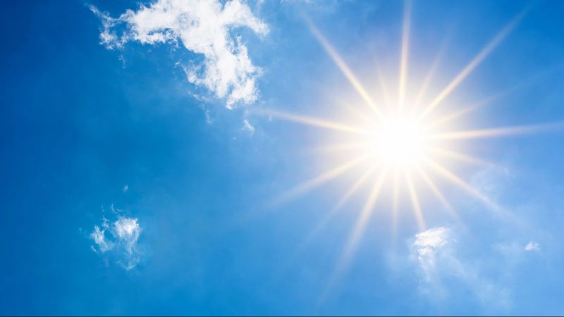 blauer Himmel mit gleißender Sonne und wenigen Schleierwölkchen